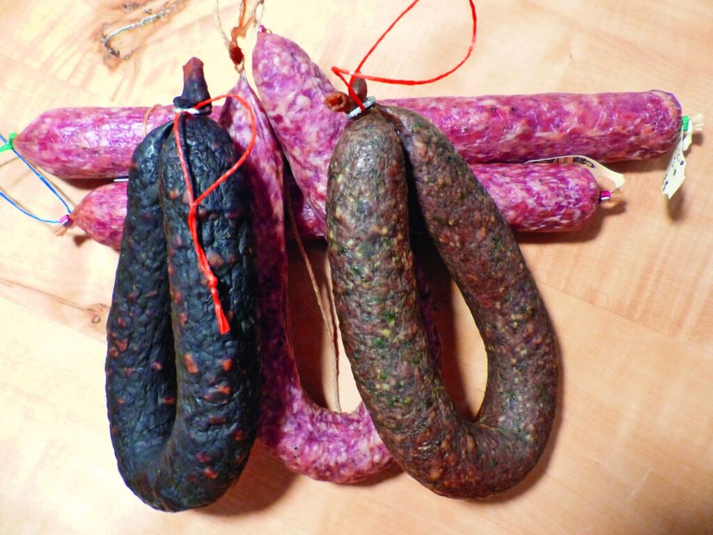 Verschiedene Wurstsorten liegen auf einem Holzbrett.